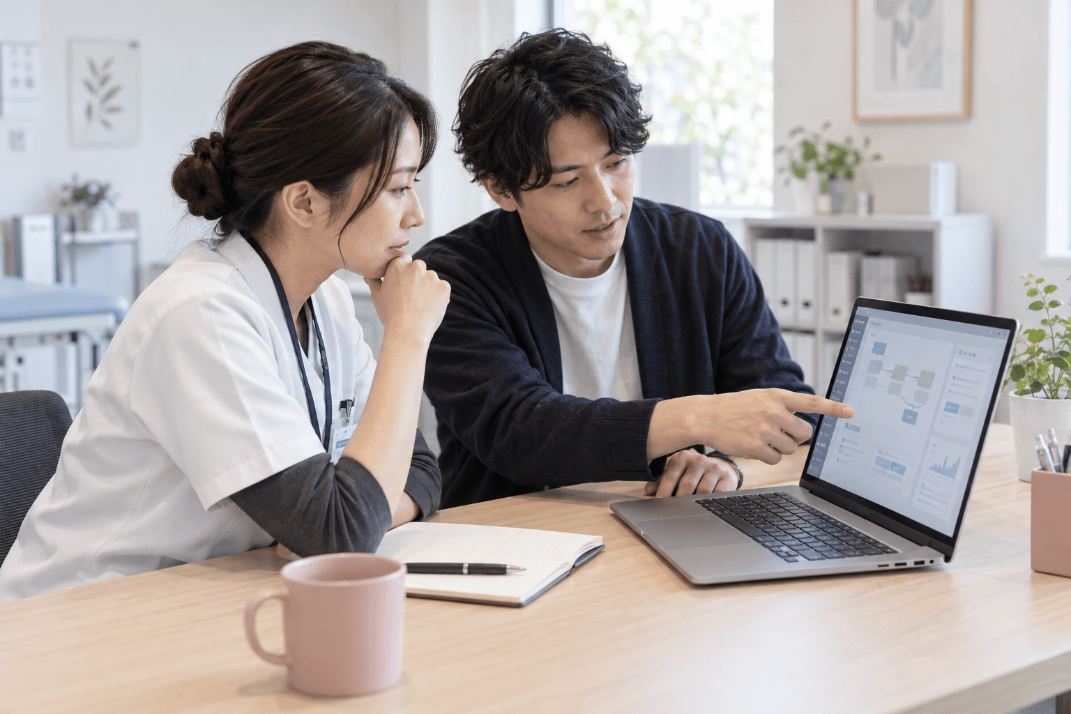 現場の担当者とエンジニアが、パソコンで業務フローを検討するイメージ